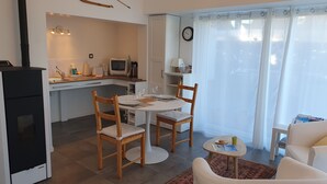 A compact living space with a kitchenette, dining area, and seating. - Gîte PMR Balade Océane Lodonnec (Loctudy)