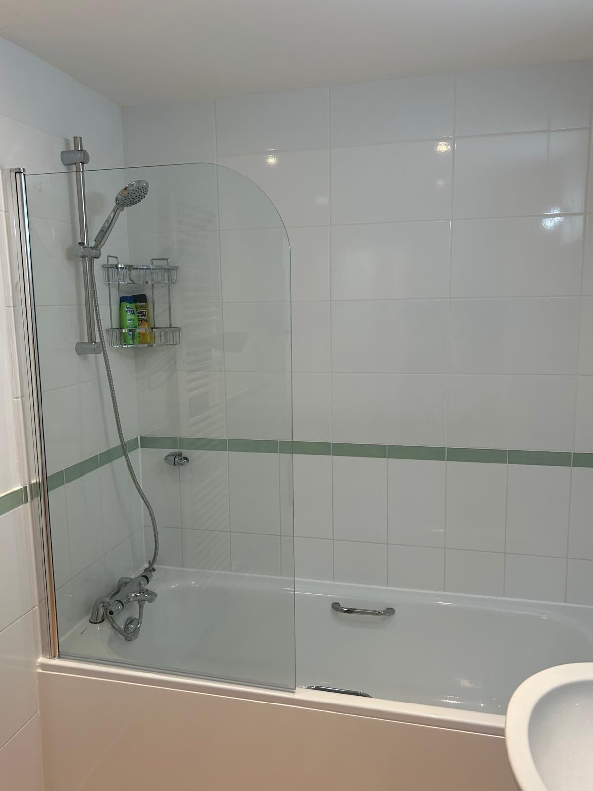 Moderni kylpyhuone, jossa on lasiseinällä varustettu suihku, kylpyamme ja wc.