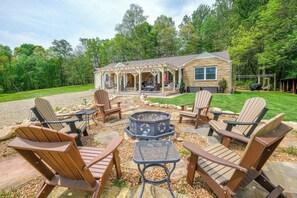 A wooden cabin with a covered patio, outdoor seating, and a fire pit. - Gameroom, Sleeps 15, Fishing Pond and Mountain View (Sevierville)
