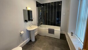 Ein modernes Badezimmer mit Toilette, Waschbecken und Badewanne.