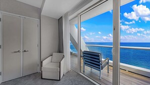 A room with a large sliding glass door leading to a balcony with a view of the ocean. - Holiday Waves: Oceanview Charm at Central Beach (Fort Lauderdale)