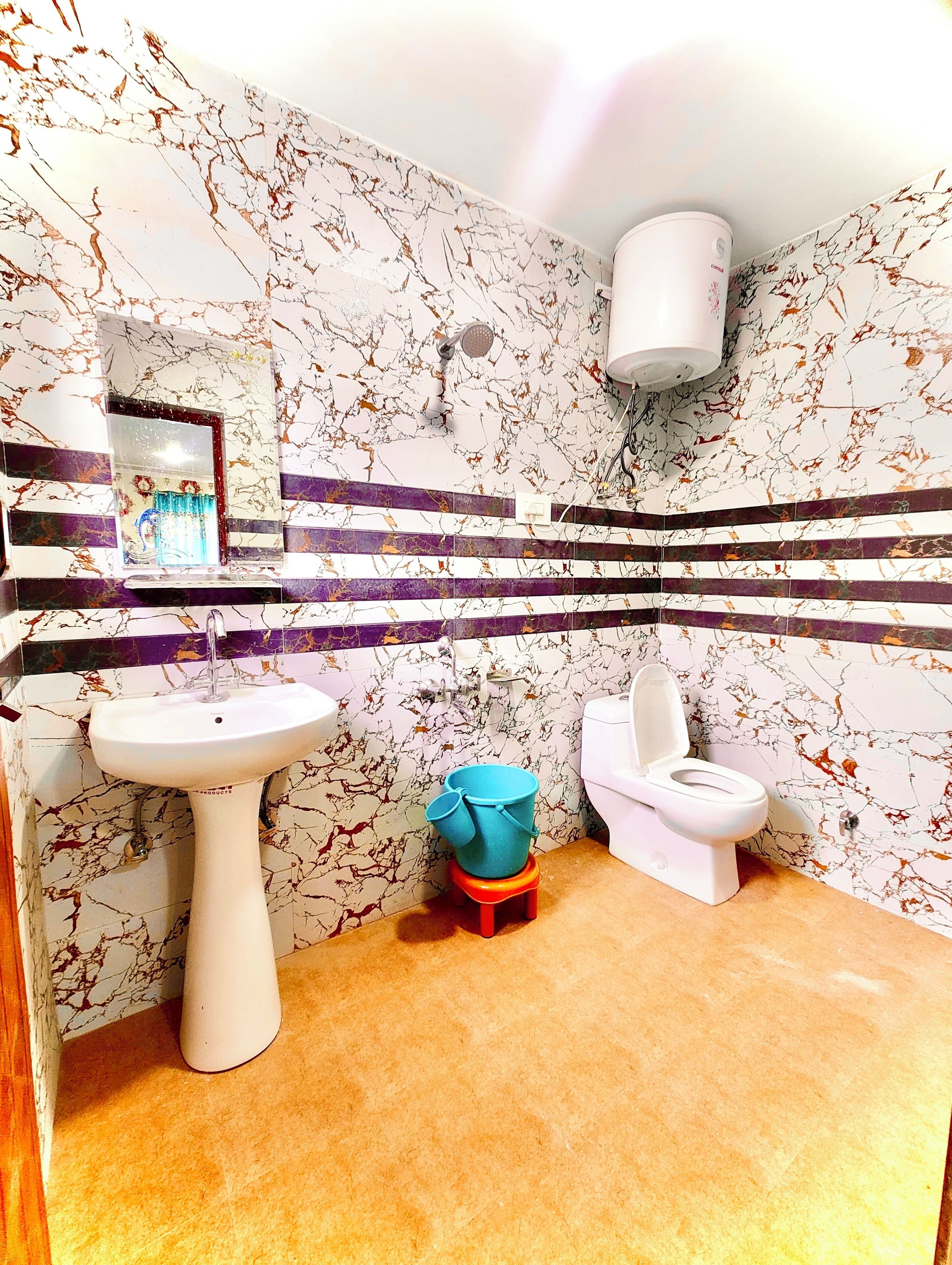 A bathroom with a white sink, a toilet, and a showerhead.