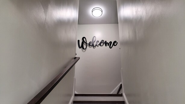 Un escalier sur lequel on peut lire, au-dessus, l’inscription « Bienvenue ».