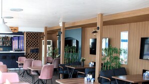 Un ristorante moderno con rivestimenti in legno, un'area bar e diverse disposizioni di posti a sedere.