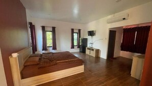 A bedroom with a large bed, a TV, and a desk. - 7Zee View (Nakhon Nayok)