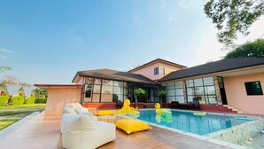 A modern house with a swimming pool, outdoor furniture, and a covered patio area. - 7Zee View (Nakhon Nayok)
