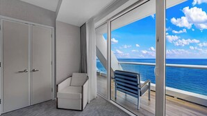 A modern room with a sliding glass door leading to a balcony with a view of the ocean. - Beachfront Condo Fort Lauderdale Beach (Fort Lauderdale)