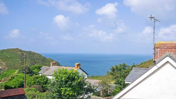 A coastal view with a white building, a brick chimney, and a metal antenna. - Rockham Bay View - Sleeps 6 Mortehoe (Woolacombe)