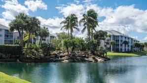 Ein Hotel mit Pool, Palmen und einem Golfplatz im Hintergrund.
