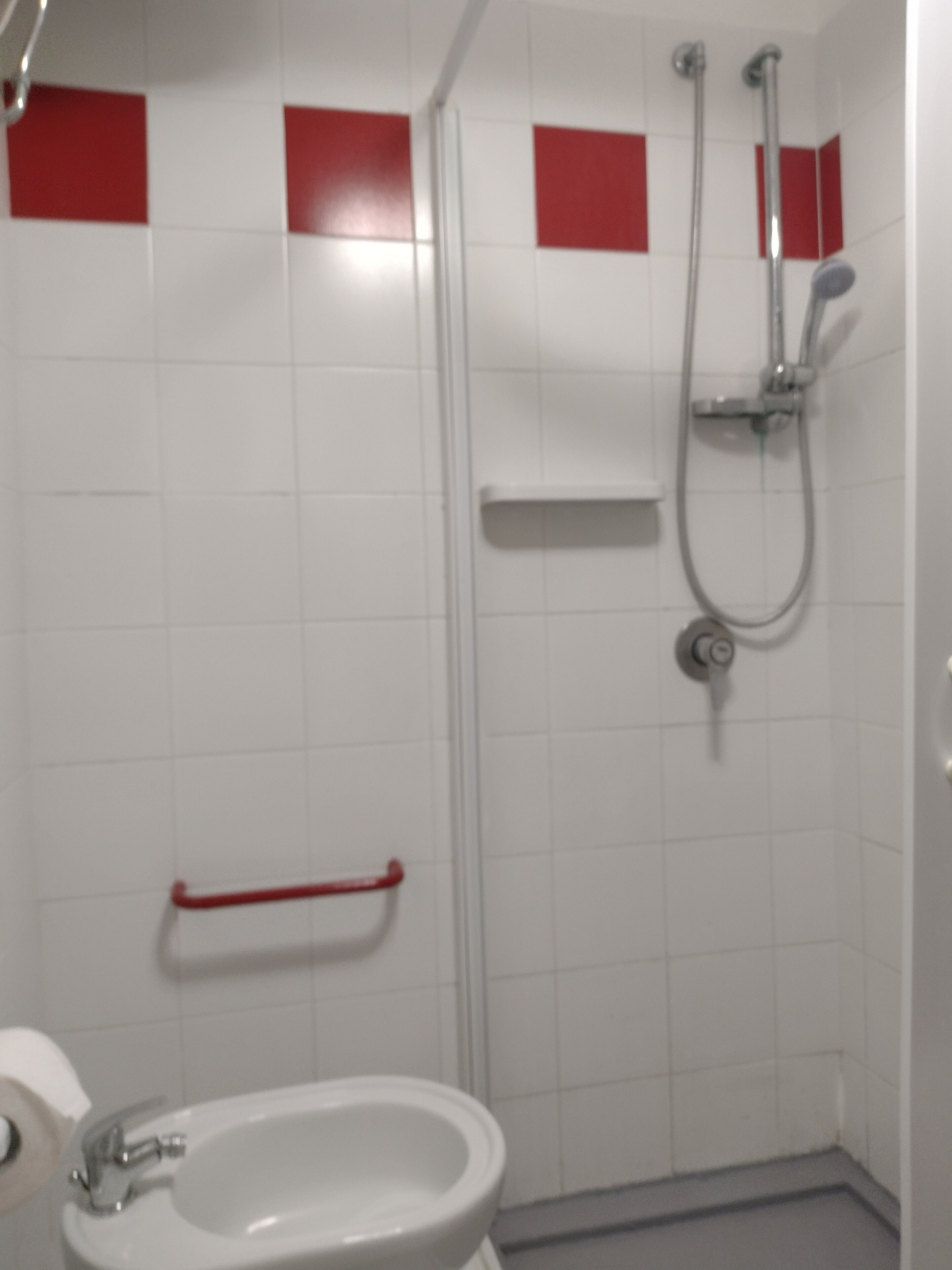 A bathroom with a toilet, sink, and shower.