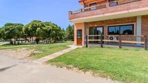 A two-story building with a brick facade, large windows, and a balcony. - Countryside house - 6 (Carbonia)