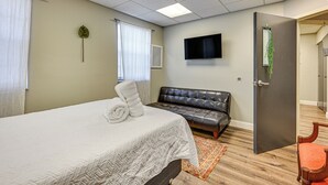 Ett hotellrum med en säng, en soffa, en tv och en dörr.