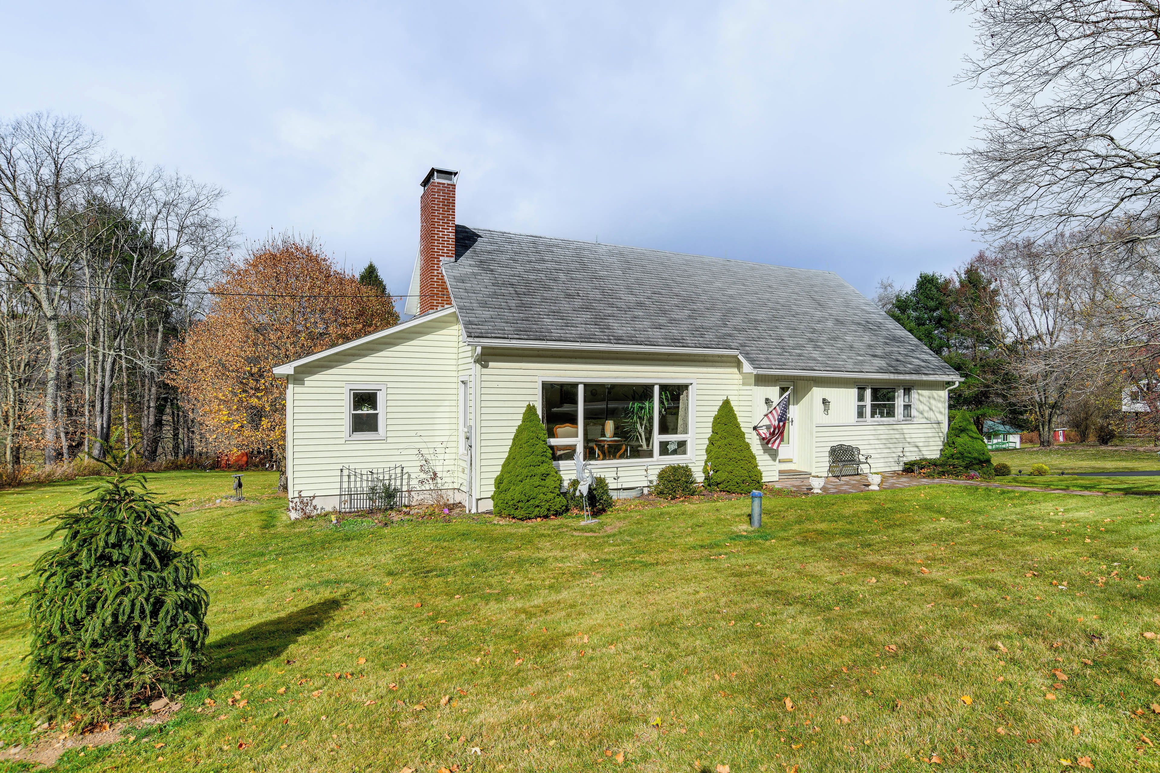 A single-story house with a gabled roof, a chimney, and a front porch.