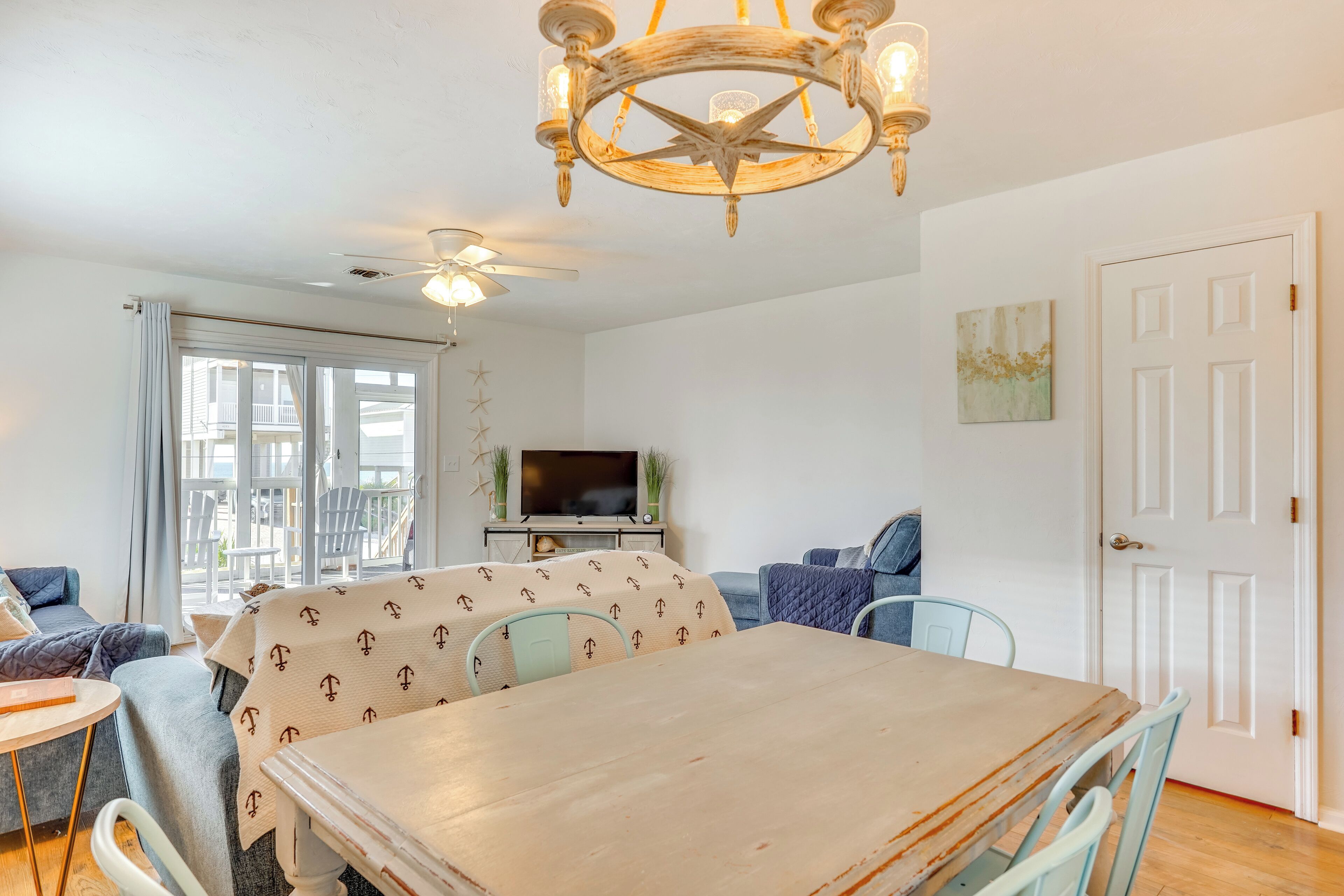 A dining area with a wooden table, chairs, and a ceiling fan.