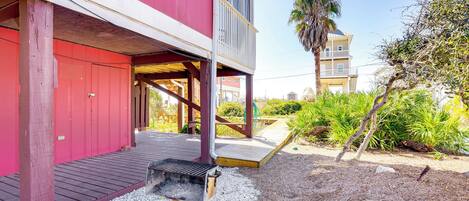 A red building with a wooden deck and a barbecue grill in the foreground.