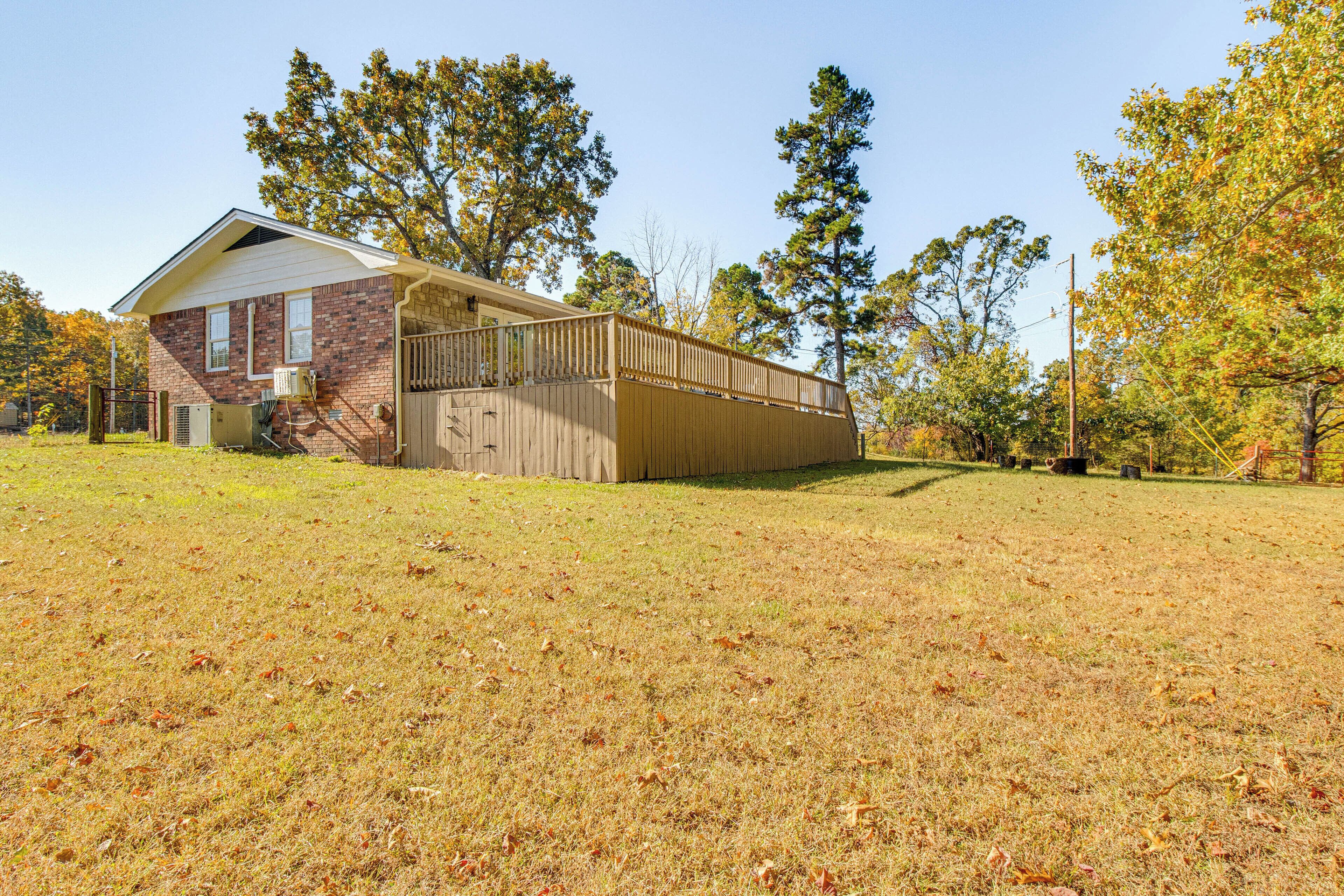 A two-story house with a brick exterior and a wooden deck.