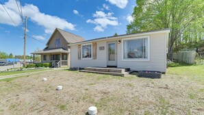 A single-story mobile home with a front porch and a small deck.