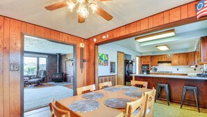 A wooden interior with a dining table, chairs, and a kitchen area. - 1 Mi to Hot Springs State Park: Rustic Wyoming Gem (Thermopolis)