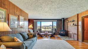 A cozy living room with a fireplace, a sofa, two armchairs, and a view of the outdoors. - 1 Mi to Hot Springs State Park: Rustic Wyoming Gem (Thermopolis)