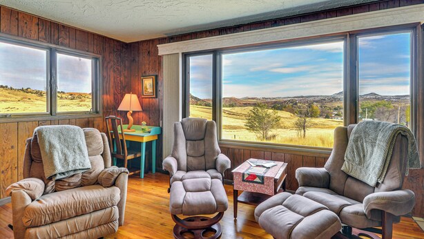 A room with three reclining chairs, wooden walls, and large windows offering a view of a rural landscape. - 1 Mi to Hot Springs State Park: Rustic Wyoming Gem (Thermopolis)