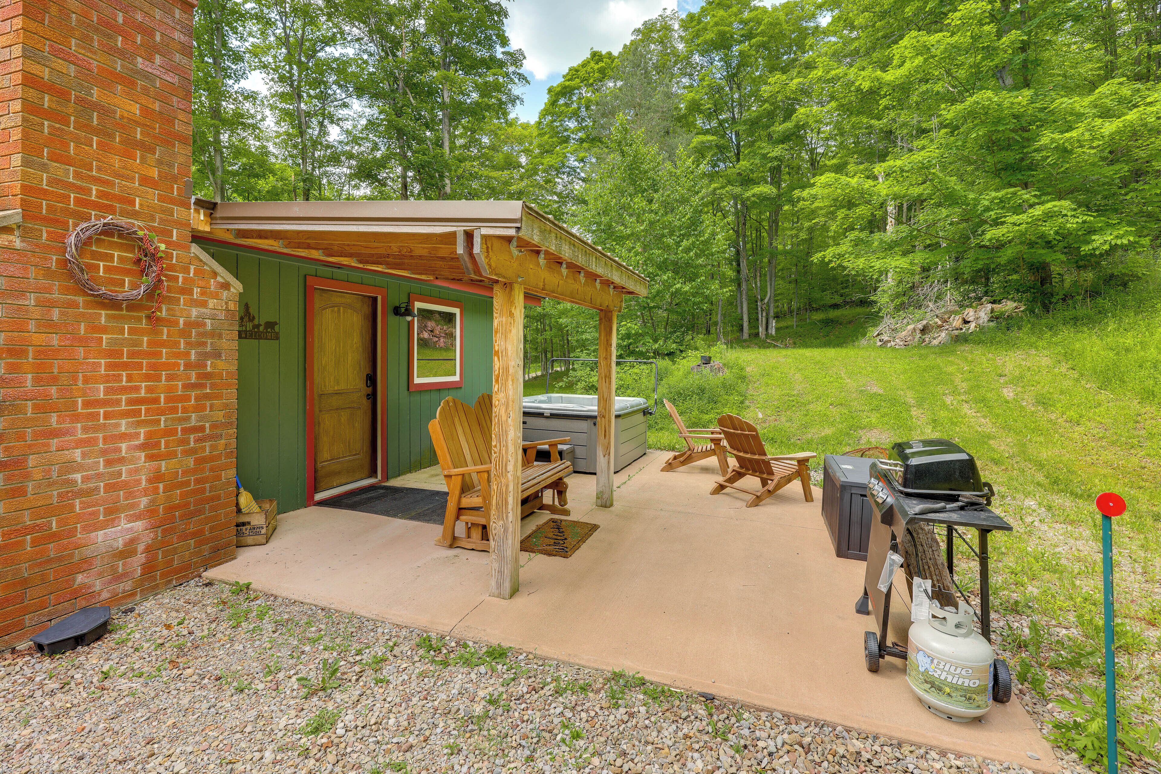 A covered patio with outdoor seating, a barbecue grill, and a propane tank.