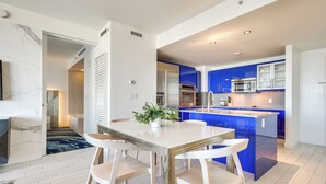 A modern kitchen with blue cabinets, a central island, and stainless steel appliances.