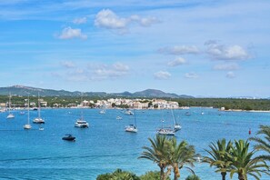 A coastal town with numerous sailboats on the water, a beach, and a backdrop of hills. - Mesquida Holiday Home for 10 People with Sea Views and Private Pool Portocolom (Felanitx)