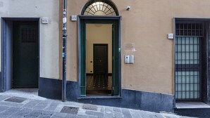 A building with a green door and a window with a metal grid. There are two signs on the wall, one with the number 29 and another with the number 25.
