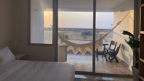 A bedroom with a bed, a hammock, and a balcony with a view. - w Divine Loft w Ocean View in Crespo (Cartagena)