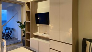 A modern living room with a TV mounted on a wall, a hammock, and a seating area with a plant. - w Divine Loft w Ocean View in Crespo (Cartagena)