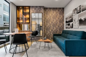 A modern hotel room with a dining area, a sofa, and a wall with framed pictures. - w Elegant Loft w Terrace in Santa Barbara (Bogotá)