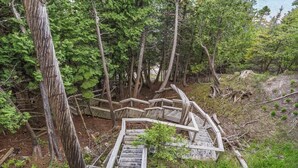 A wooden staircase leading into a forested area.