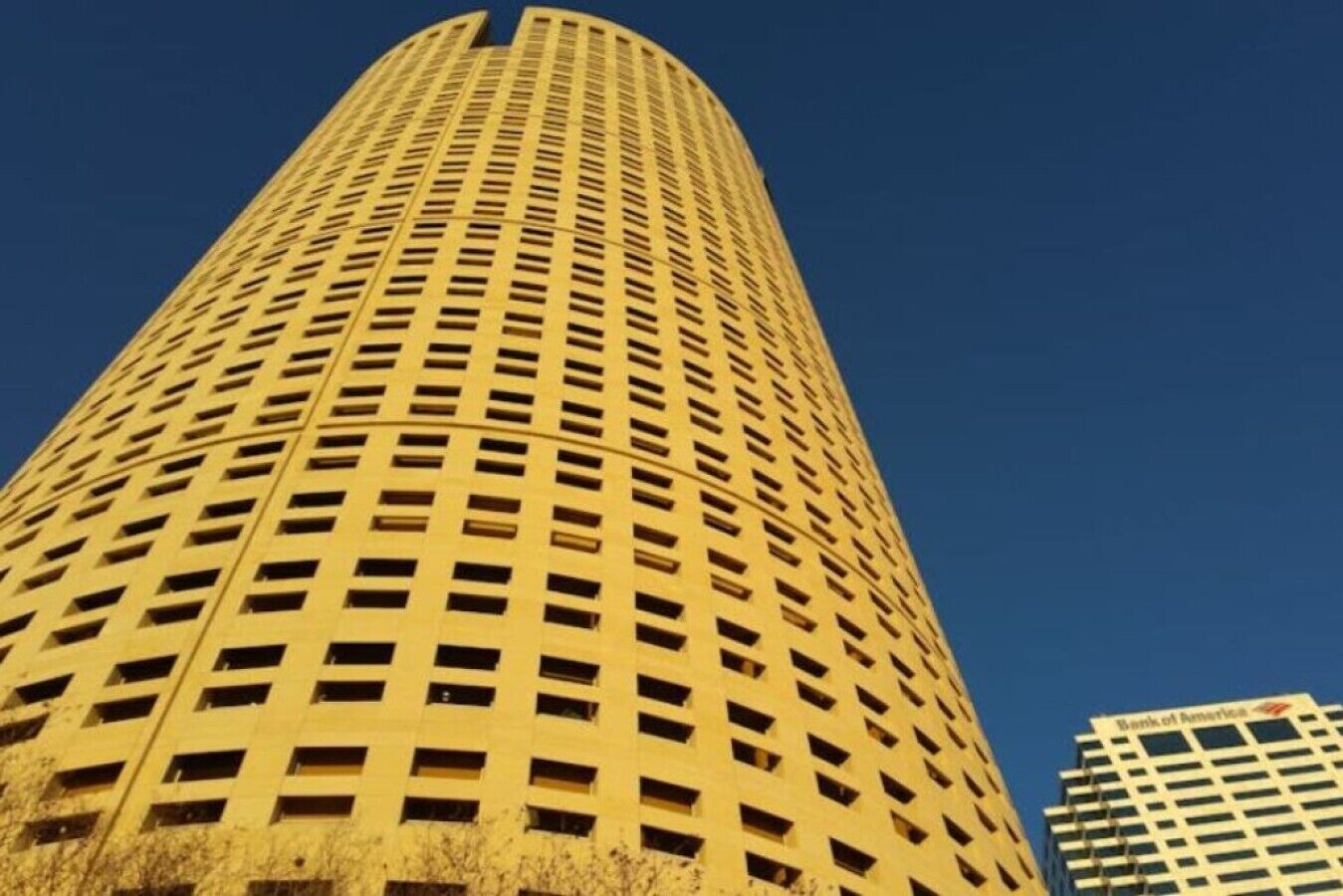 Un edificio alto y cilíndrico con una cuadrícula de ventanas.