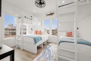 A room with bunk beds, a large window, and a view of a building outside. - New home in CS South with access to 20+ resort like amenities (Port Aransas)