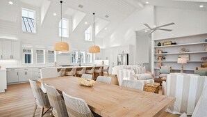Une cuisine spacieuse avec de hauts plafonds, de grandes fenêtres et des appareils électroménagers modernes.