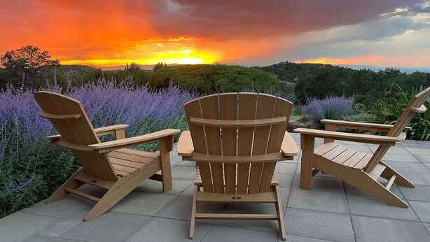 Three wooden Adirondack chairs on a patio with a sunset view. - Sunset Mountain Ranch - 5 Bedroom (Santa Fe)