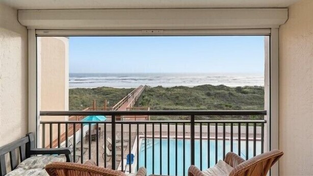 Ein Balkon mit Blick auf das Meer und einen Pool.
