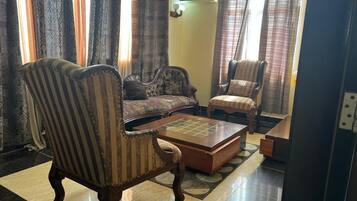 Una sala de estar con sillones a rayas, un sofá y una mesa de centro.