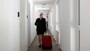 A hotel corridor with white walls, a tiled floor, and doors on both sides. - Arbio I Cozy Studio Balcony WKO Steiermark Graz (Graz)