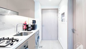 Una cocina moderna con estufa a gas, lavamanos y lavadora.
