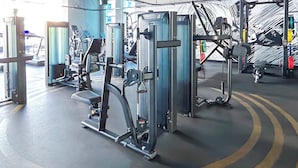 A gym with various exercise machines, including a leg press and a chest press. - Balcony Bliss: Cozy Studio With Marina Views (Dubai)