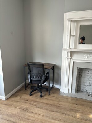 Cozy retreat with a fireplace, desk, and mirror.