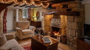 Una sala de estar acogedora con chimenea de piedra, asientos cómodos y una mesa de centro de madera.