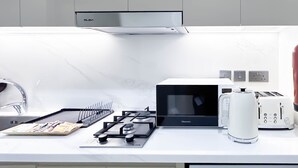 Eine moderne Küche mit Gasherd, Mikrowelle, Toaster und Feuerlöscher.
