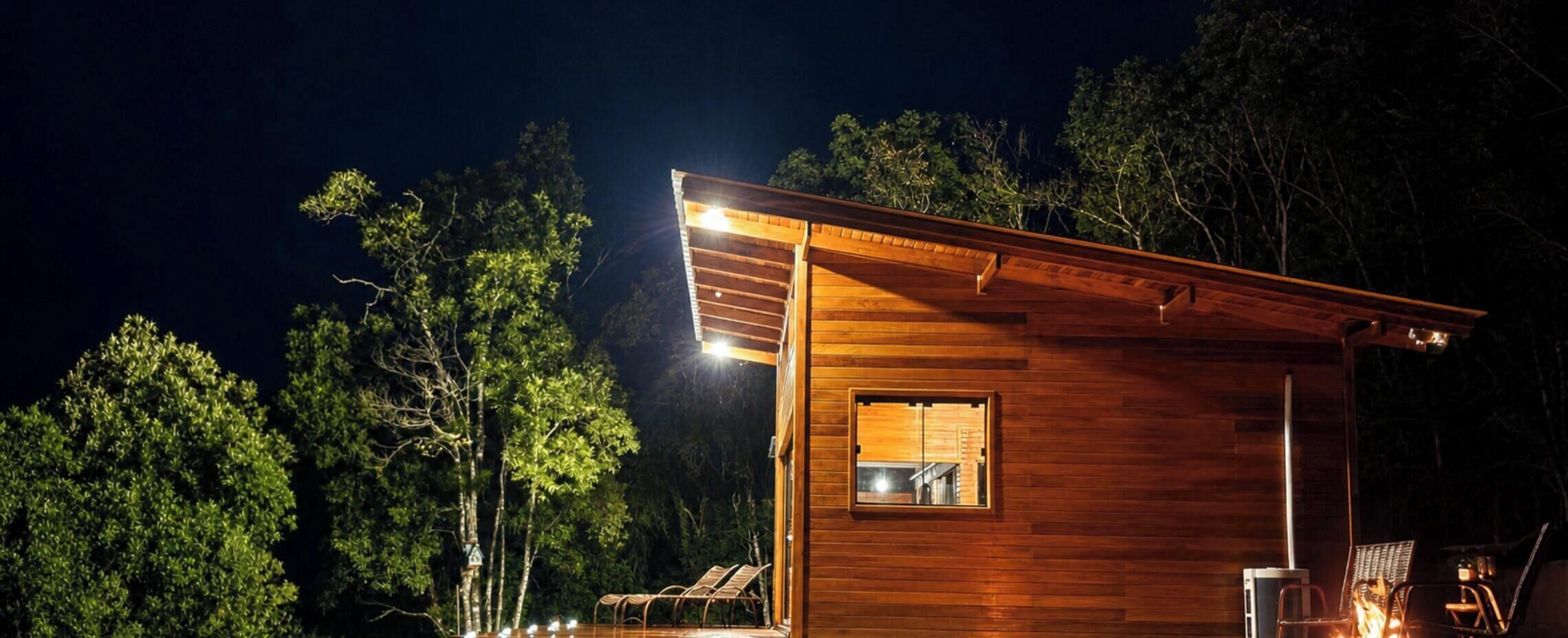 Une cabane en bois avec une seule fenêtre visible, entourée d’arbres.