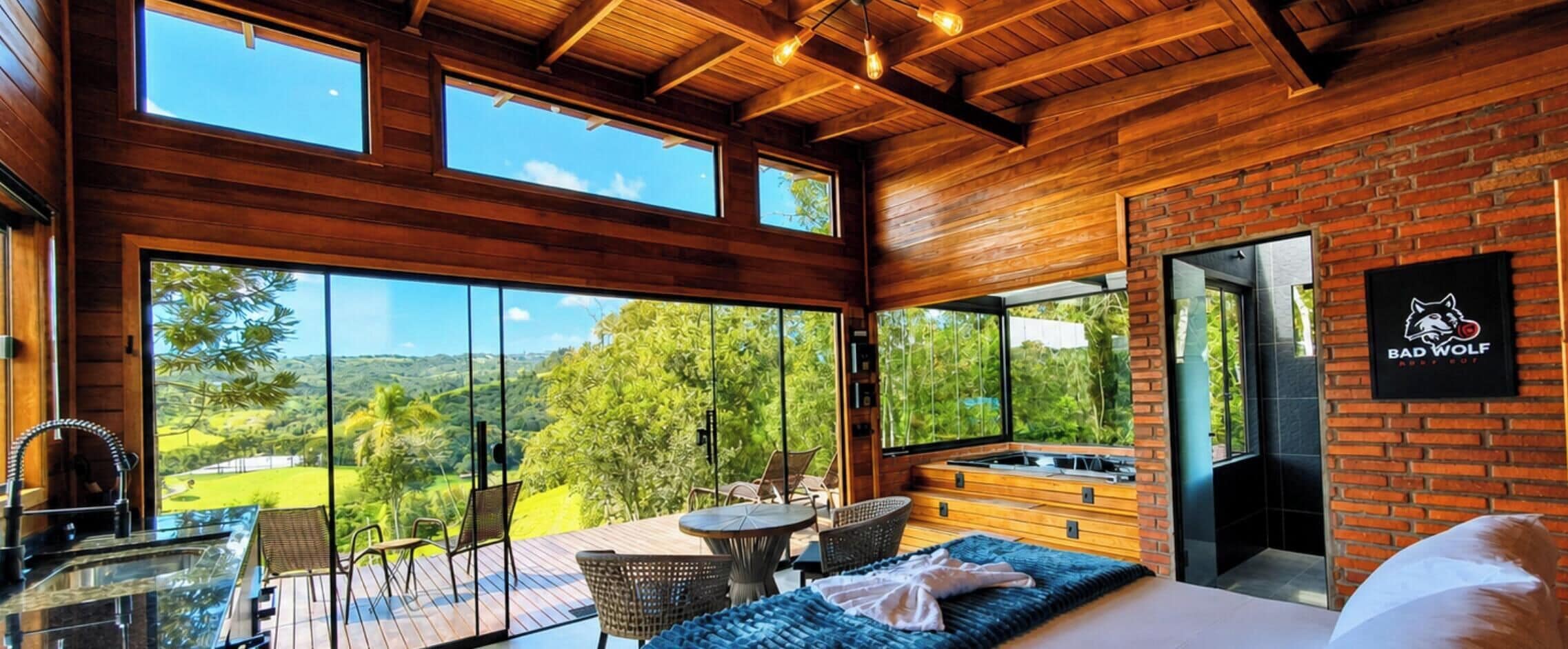 Une pièce moderne dotée d’un grand mur en verre, d’un plafond en bois et d’un espace salon avec une table et des chaises.