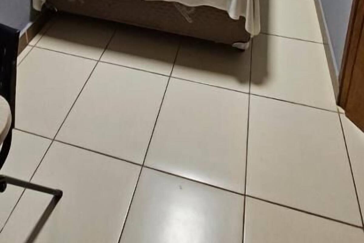 Un dormitorio pequeño y ordenado con cama, aire acondicionado y cortina.