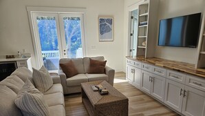 A modern living room with a sofa, a coffee table, and a TV. - The Seashelle is a New Four Bedroom, Four ½ Bath home with a Pool. (Fripp Island)