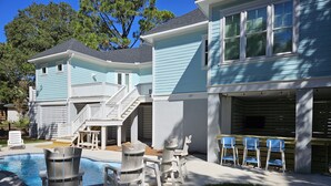 A two-story house with a pool, outdoor seating, and a covered patio area. - The Seashelle is a New Four Bedroom, Four ½ Bath home with a Pool. (Fripp Island)
