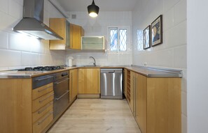 apartman, teraszos udvar (2 Bedrooms) | Privát konyha | Nagyméretű hűtő/fagyasztó, mikrohullámú sütő, sütő és mosogatógép